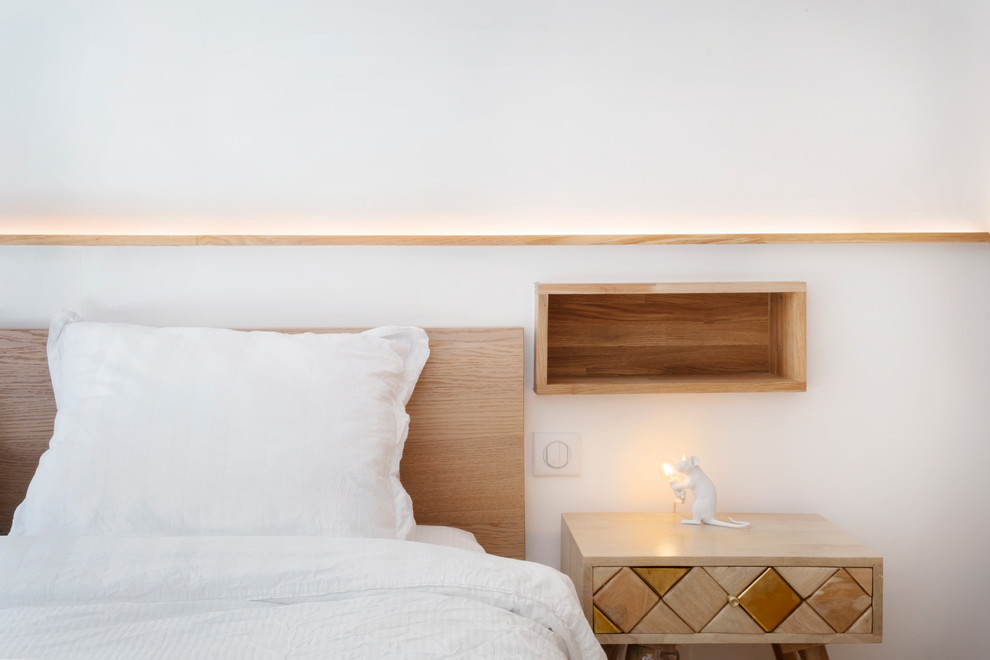 Imagen de dormitorio principal nórdico pequeño sin chimenea con paredes blancas, suelo de madera clara y suelo beige
