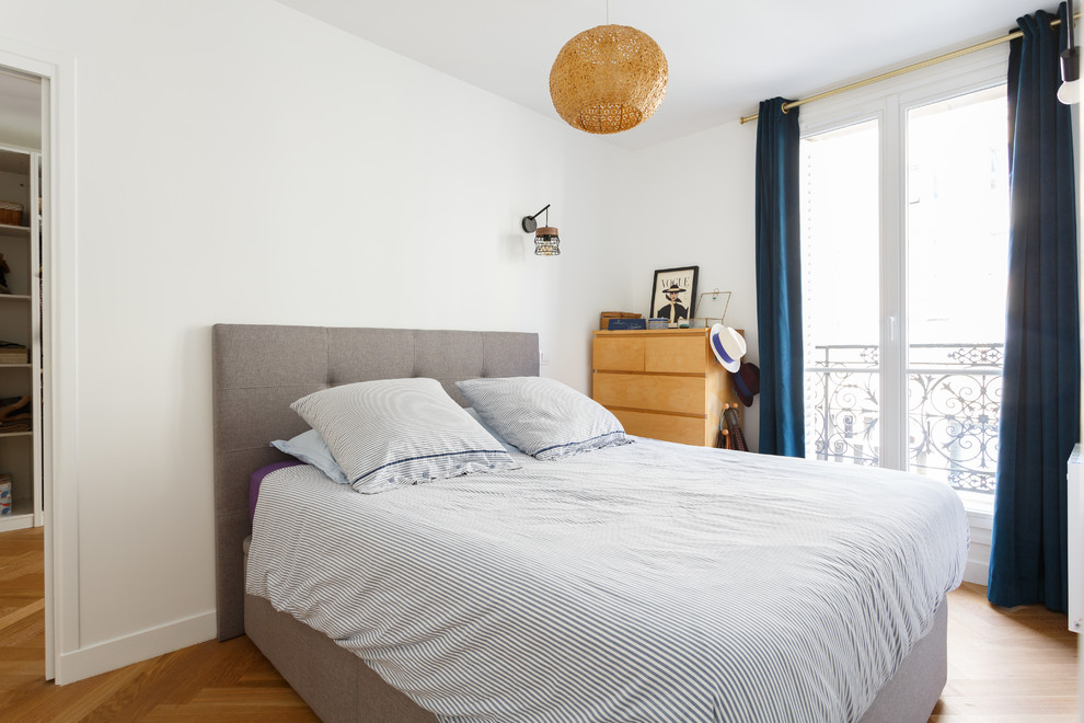 Inspiration for a small scandi master bedroom in Paris with white walls, light hardwood flooring and beige floors.