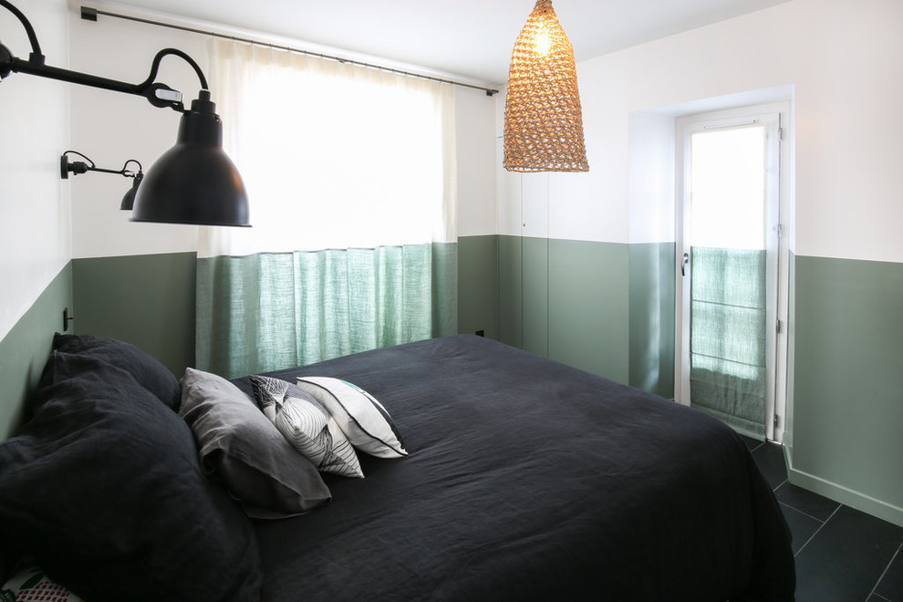Modelo de dormitorio principal actual pequeño sin chimenea con paredes verdes, suelo de baldosas de cerámica y suelo negro