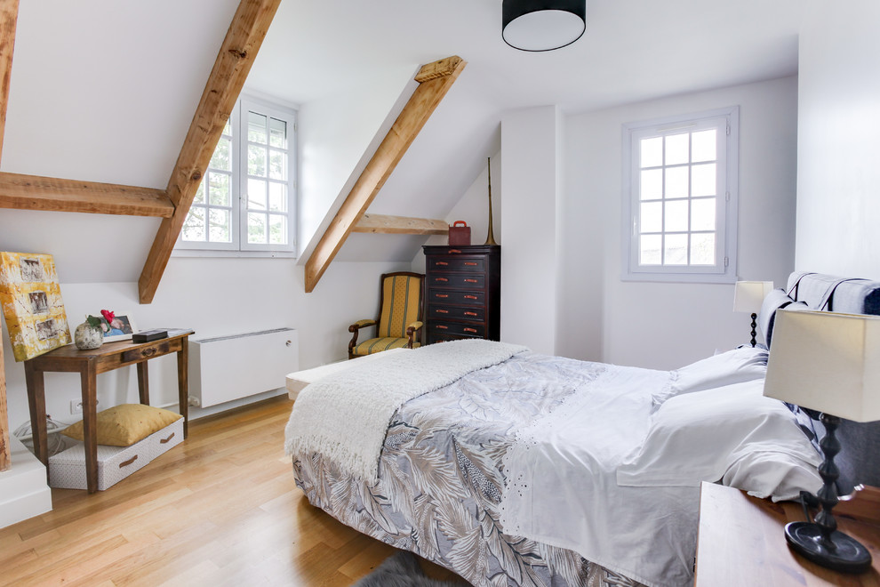 Medium sized contemporary master bedroom in Paris with white walls, light hardwood flooring and beige floors.
