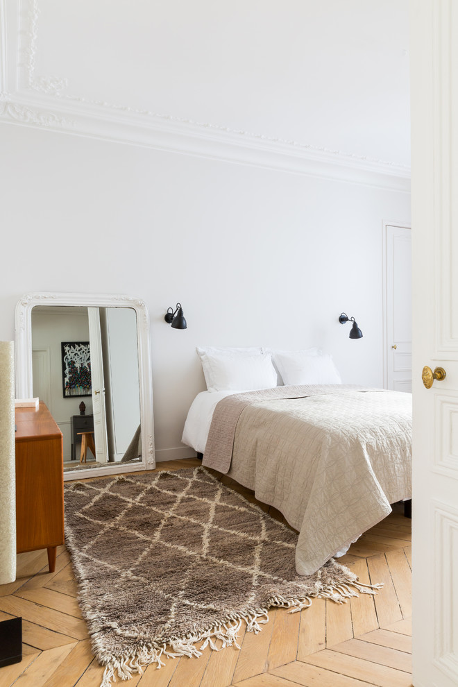 Diseño de dormitorio contemporáneo con paredes blancas, suelo de madera clara y suelo beige