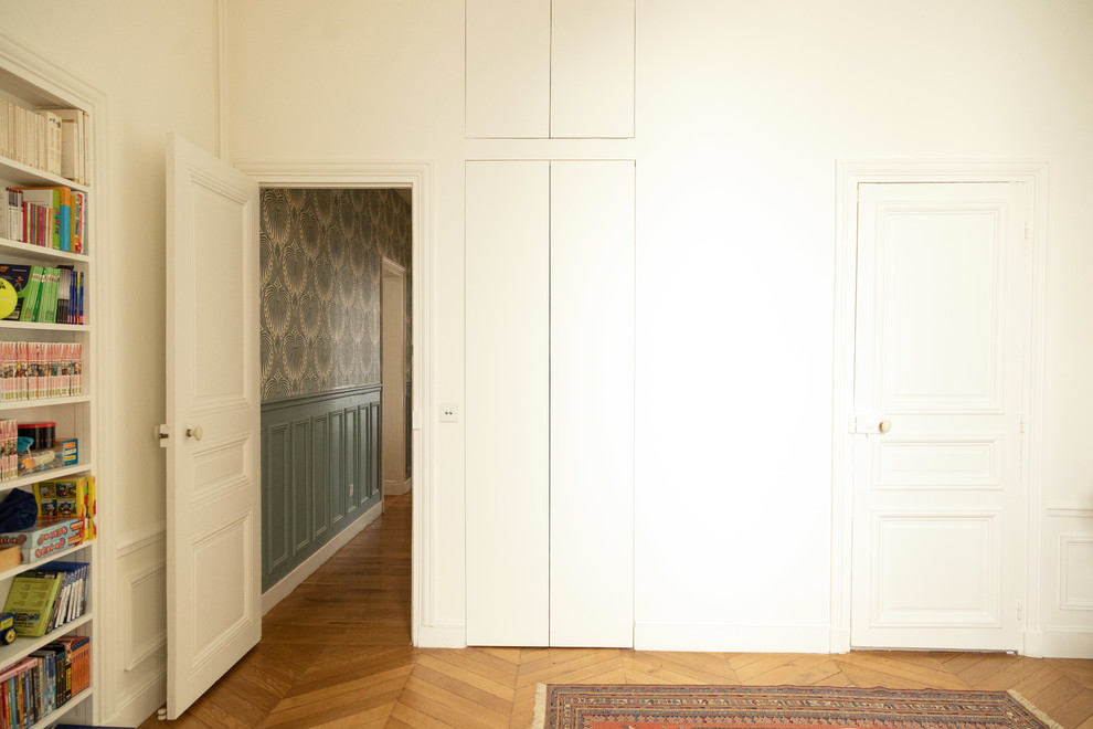 Esempio di una camera matrimoniale contemporanea di medie dimensioni con pareti bianche, pavimento in legno massello medio, pavimento marrone e nessun camino