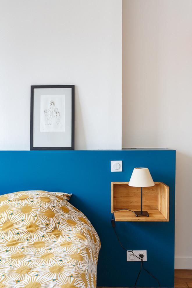 Kleines Modernes Hauptschlafzimmer ohne Kamin mit bunten Wänden, braunem Holzboden und braunem Boden in Paris