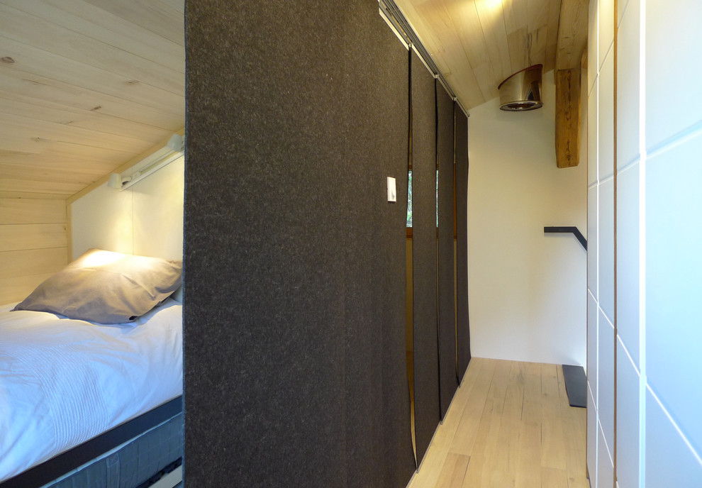 Kleines Modernes Schlafzimmer ohne Kamin, im Loft-Style mit schwarzer Wandfarbe und hellem Holzboden in Sonstige