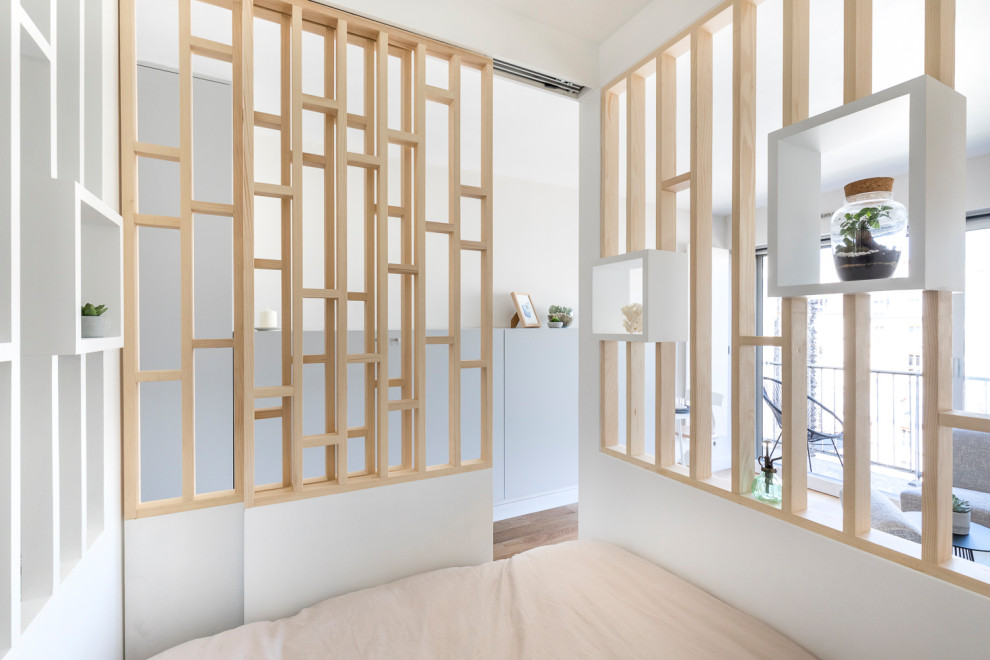 Ispirazione per una piccola camera matrimoniale minimal con pareti bianche e pavimento in compensato