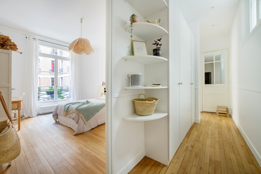 Großes Shabby-Look Hauptschlafzimmer ohne Kamin mit weißer Wandfarbe, hellem Holzboden und beigem Boden in Paris