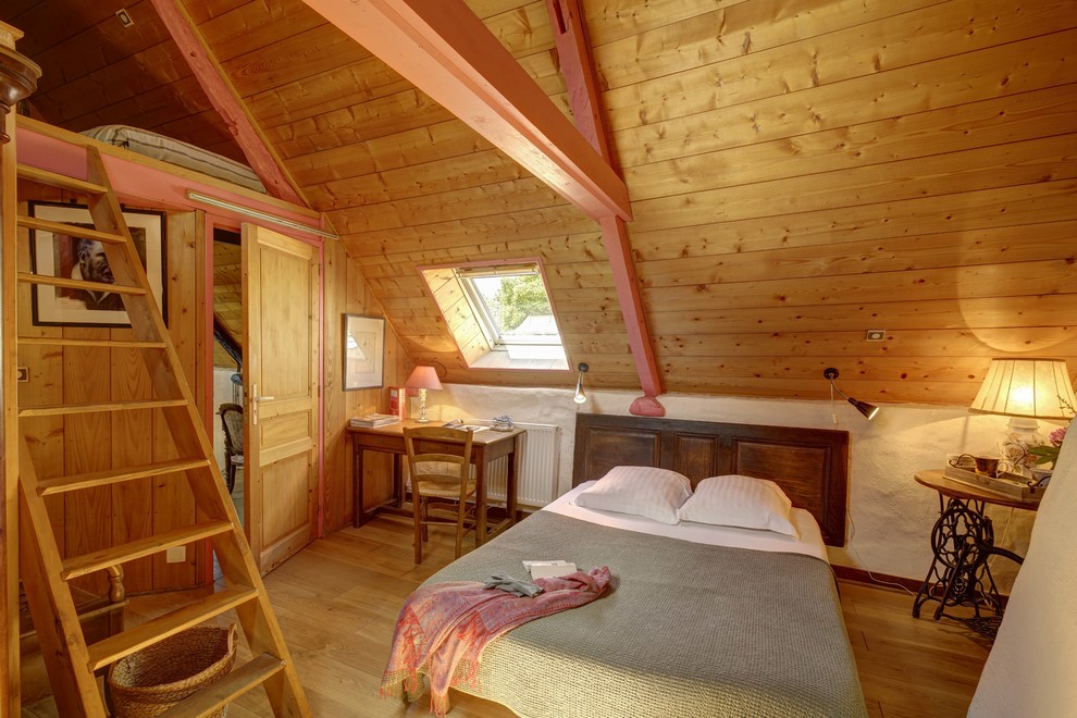 Idée de décoration pour une chambre chalet avec un mur blanc, un sol en bois brun et un sol marron.