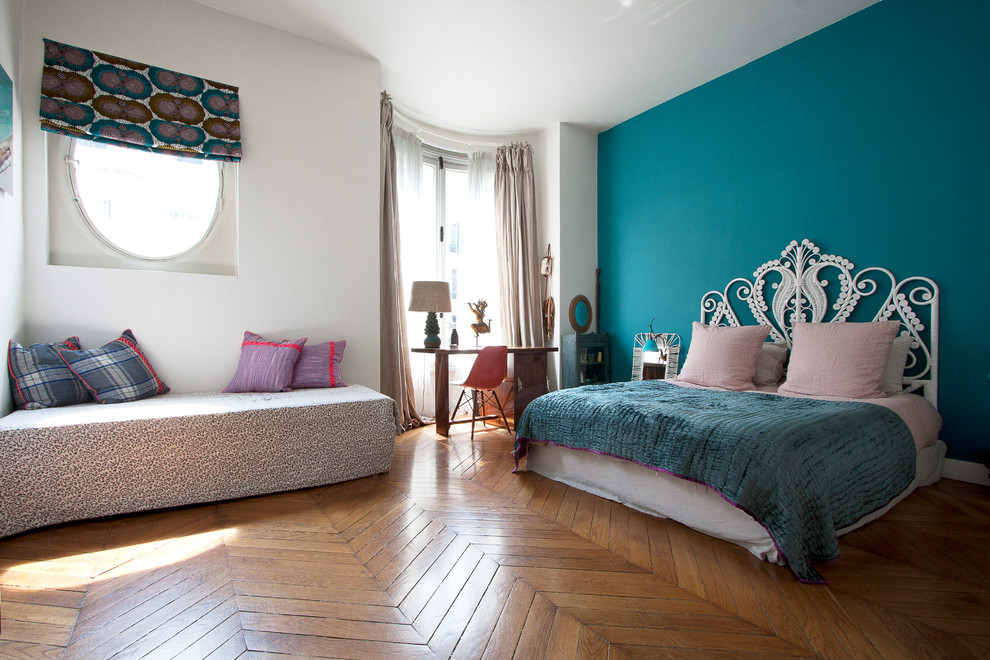 Cette photo montre une grande chambre parentale chic avec un mur bleu et parquet foncé.