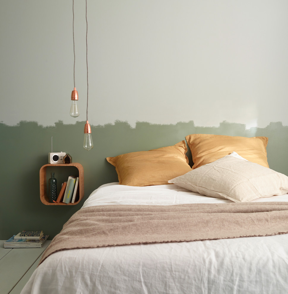 На фото: хозяйская спальня среднего размера в современном стиле с зелеными стенами и деревянным полом