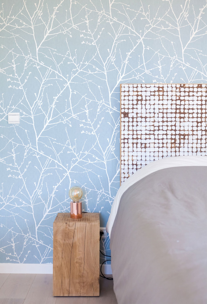 Ejemplo de habitación de invitados escandinava grande con paredes azules y suelo de madera clara