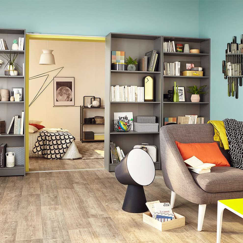 Idée de décoration pour une chambre parentale minimaliste de taille moyenne avec un mur bleu, un sol en bois brun et aucune cheminée.