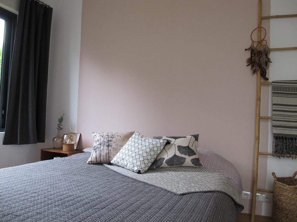 Réalisation d'une grande chambre parentale bohème avec un mur rose, parquet clair, aucune cheminée et un sol beige.