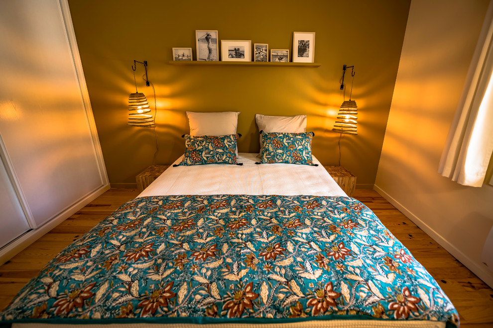 ボルドーにある中くらいなビーチスタイルのおしゃれな主寝室 (黄色い壁、無垢フローリング、茶色い床)