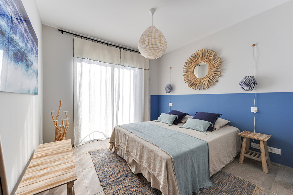 Modelo de habitación de invitados bohemia de tamaño medio sin chimenea con paredes azules, suelo de baldosas de cerámica y suelo beige