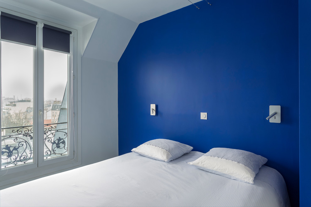 Immagine di una piccola camera matrimoniale design con pareti blu, parquet chiaro, nessun camino e pavimento beige