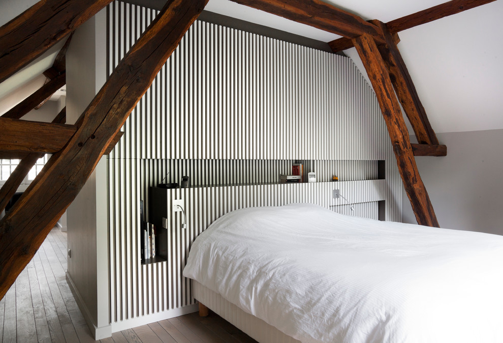 Esempio di una piccola camera da letto design con pareti grigie, parquet chiaro e nessun camino