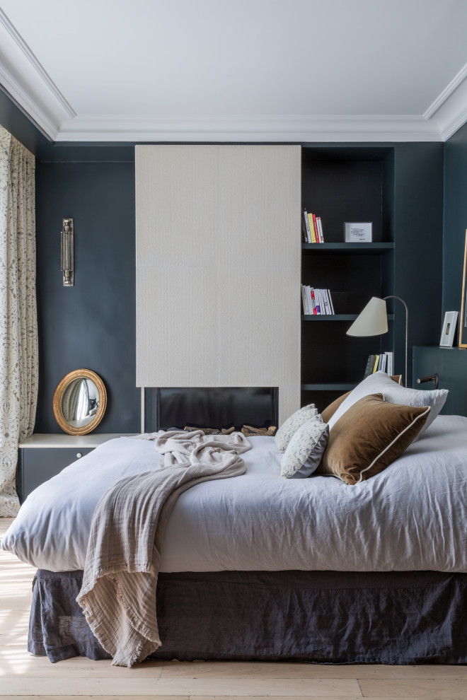 Bild på ett mellanstort funkis sovrum, med blå väggar, ljust trägolv, en bred öppen spis och beiget golv