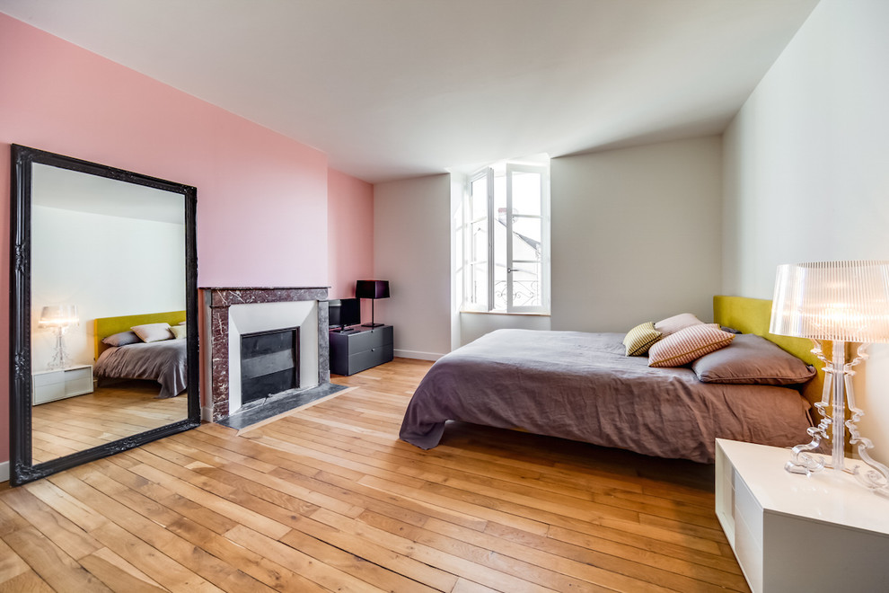 他の地域にある広いコンテンポラリースタイルのおしゃれな主寝室 (ピンクの壁、淡色無垢フローリング、石材の暖炉まわり、ベージュの床)