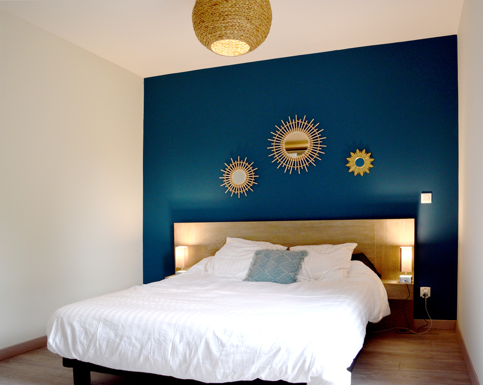 Mittelgroßes Skandinavisches Hauptschlafzimmer mit blauer Wandfarbe, hellem Holzboden und beigem Boden in Toulouse