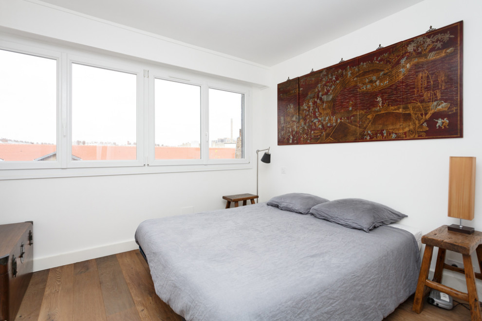 На фото: хозяйская спальня среднего размера с белыми стенами, паркетным полом среднего тона и коричневым полом без камина с