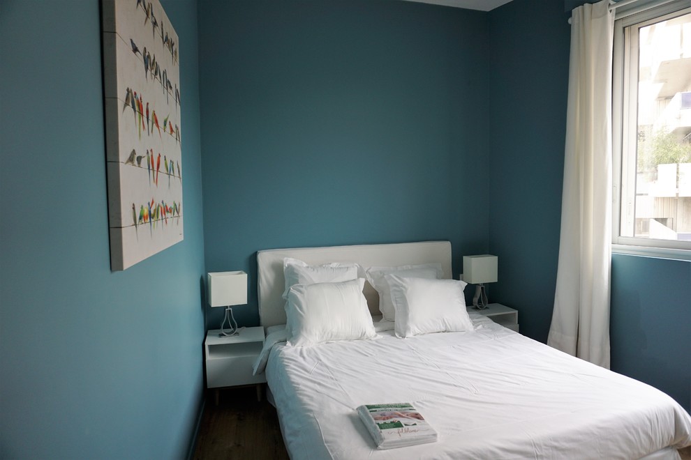 Ispirazione per una camera matrimoniale minimalista di medie dimensioni con pareti blu e parquet chiaro