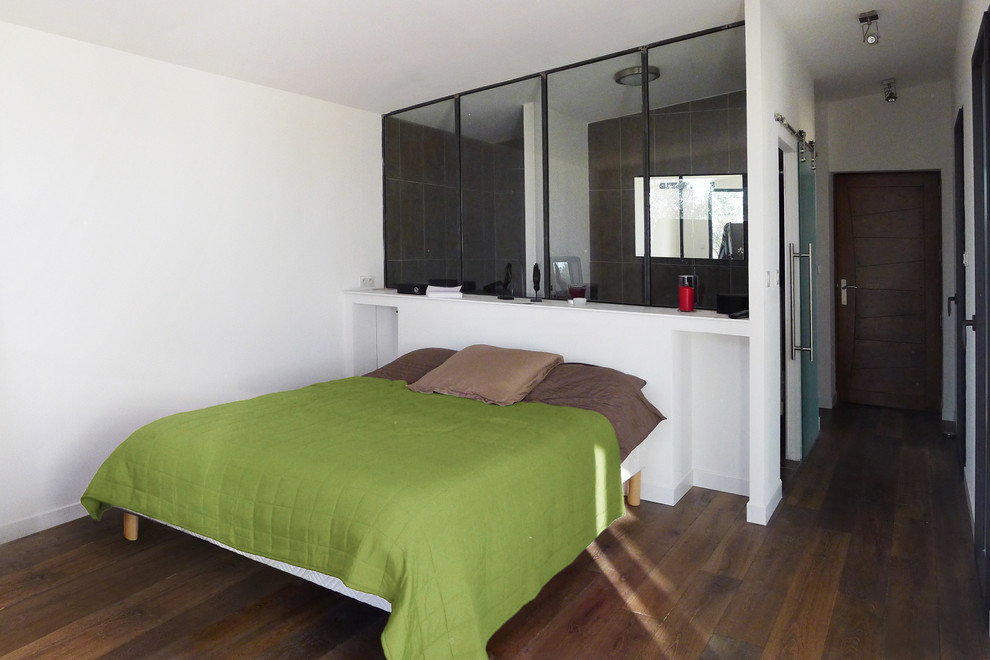 Ejemplo de dormitorio contemporáneo de tamaño medio sin chimenea con paredes blancas, suelo de madera oscura y suelo marrón
