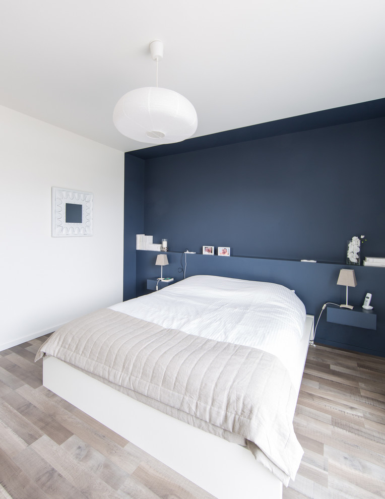 На фото: хозяйская спальня среднего размера в современном стиле с синими стенами и светлым паркетным полом с