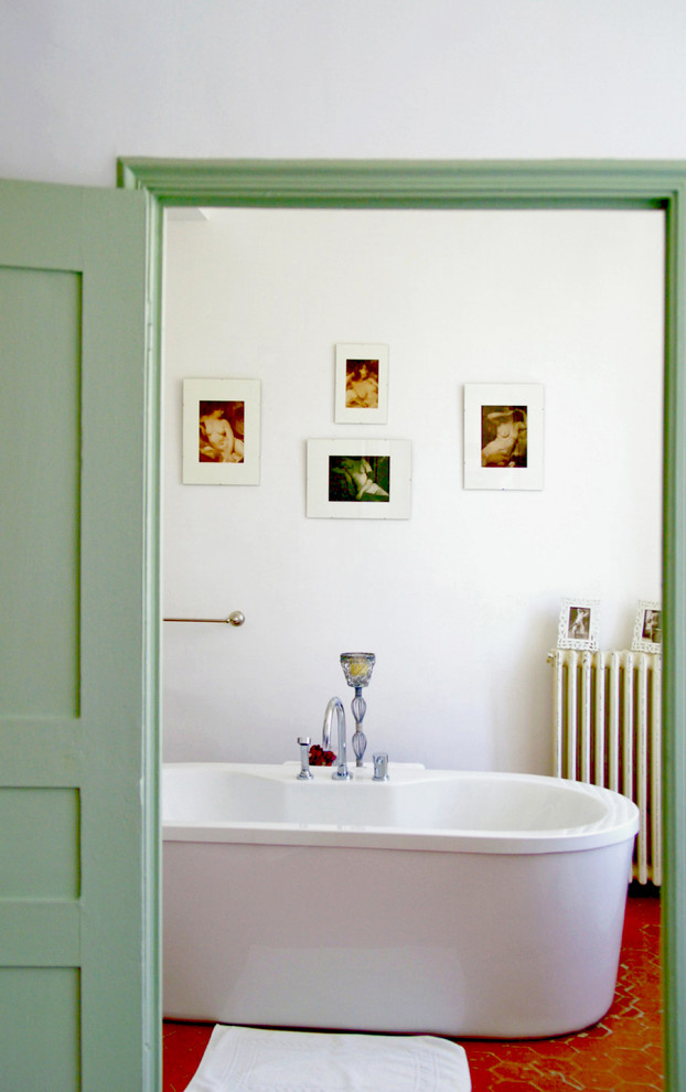 Mittelgroßes Shabby-Look Hauptschlafzimmer mit weißer Wandfarbe, Terrakottaboden, Kamin, Kaminumrandung aus Stein und rotem Boden in Nizza