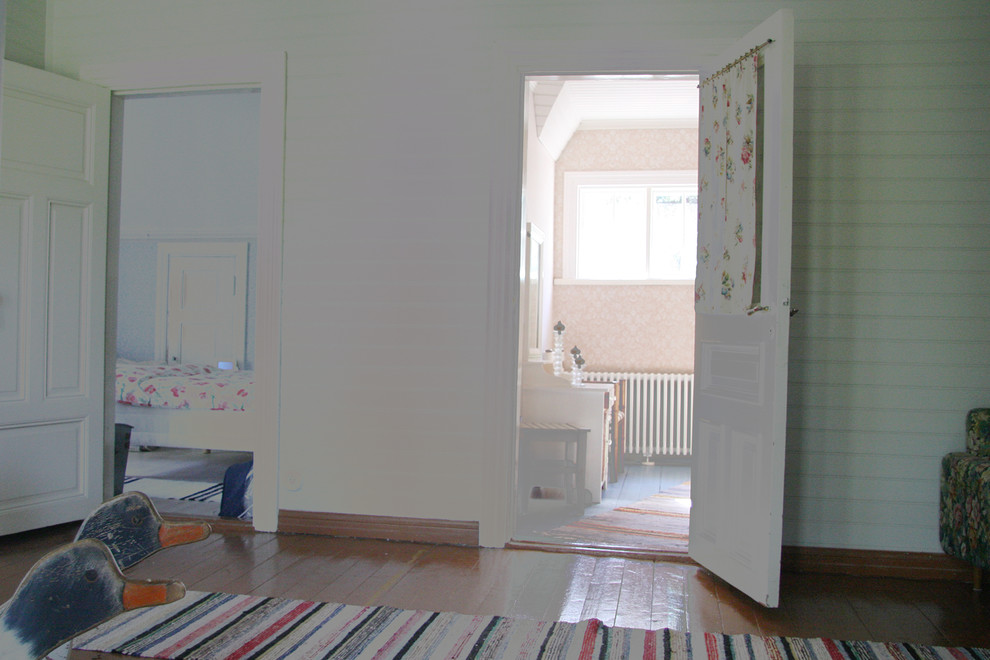 Mittelgroßes Uriges Gästezimmer mit rosa Wandfarbe, braunem Holzboden und blauem Boden in Paris