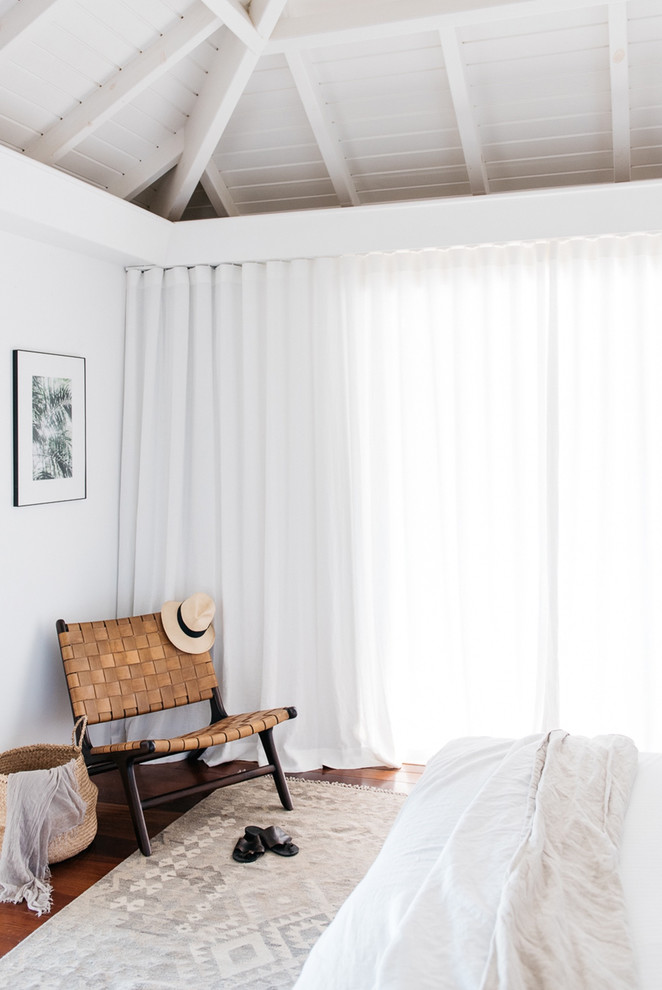 Immagine di una camera da letto costiera con pareti bianche e parquet scuro