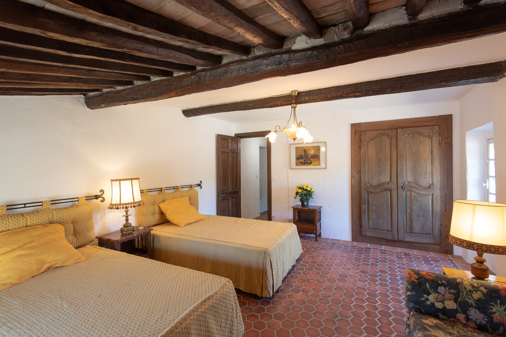 Mediterranes Schlafzimmer mit weißer Wandfarbe, Terrakottaboden und rotem Boden in Nizza