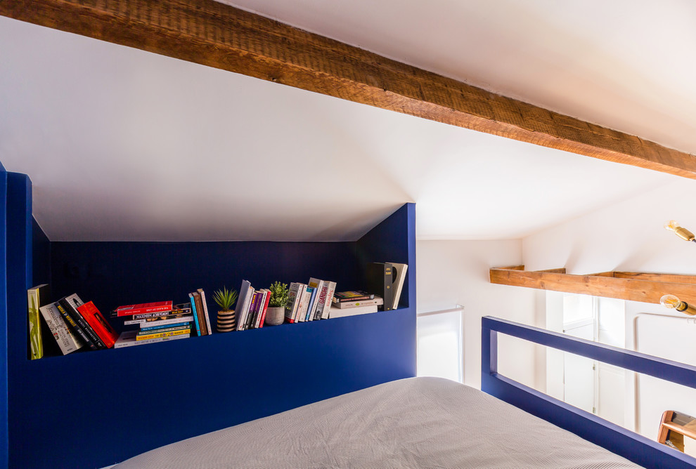 Foto de dormitorio tipo loft industrial pequeño con paredes azules, suelo de madera en tonos medios y suelo marrón