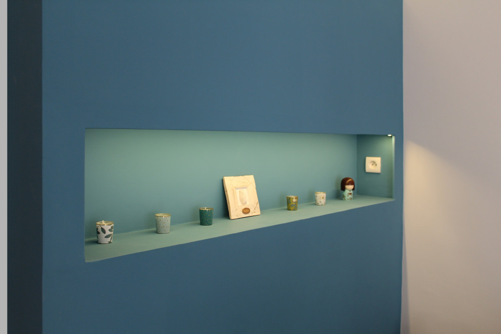 Foto de dormitorio principal minimalista pequeño sin chimenea con paredes azules, suelo laminado y suelo marrón