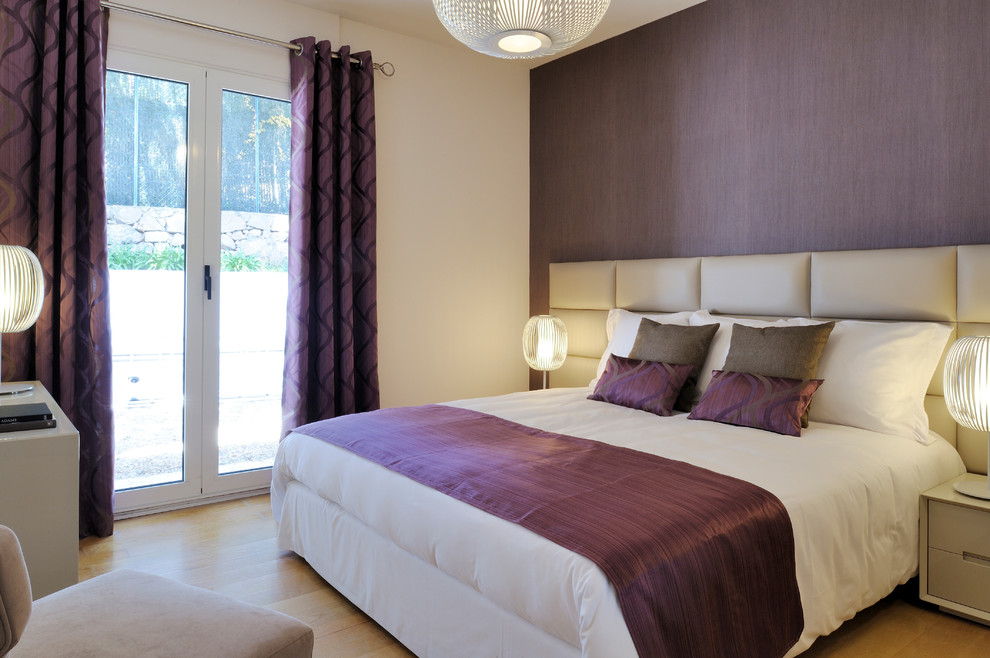Diseño de dormitorio principal contemporáneo con paredes púrpuras y suelo de madera clara