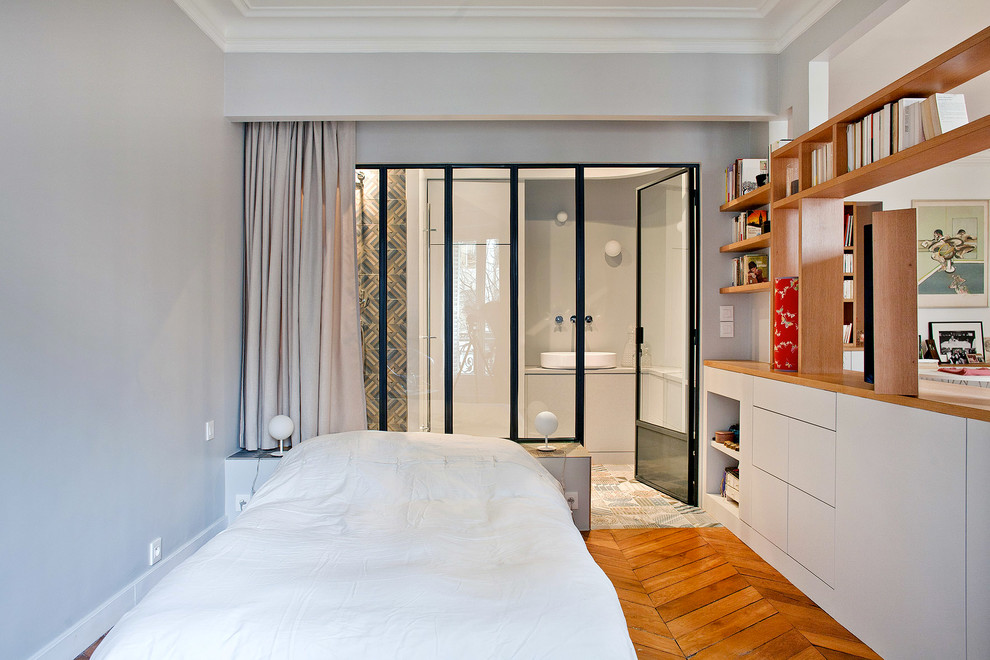 Diseño de dormitorio principal contemporáneo de tamaño medio con paredes grises y suelo de madera en tonos medios