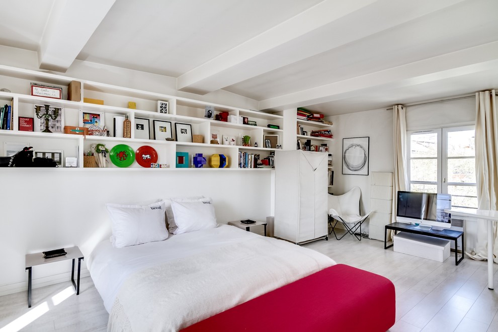 Modelo de dormitorio contemporáneo grande sin chimenea con paredes blancas y suelo de madera clara