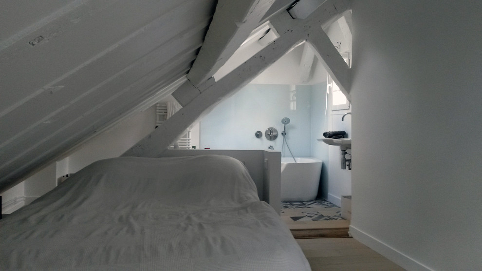 Diseño de dormitorio tipo loft actual sin chimenea con paredes blancas y suelo de madera clara