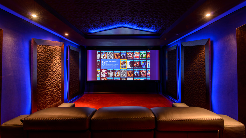Cette photo montre une grande salle de cinéma tendance fermée avec moquette, un téléviseur encastré, un mur multicolore et un sol rouge.