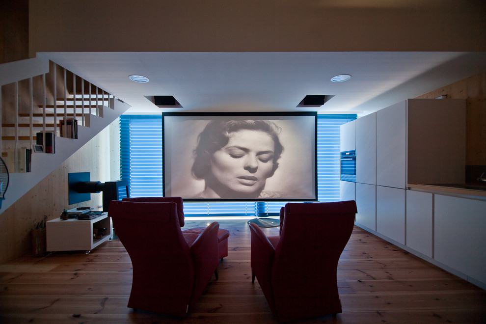 На фото: изолированный домашний кинотеатр среднего размера в современном стиле с проектором с