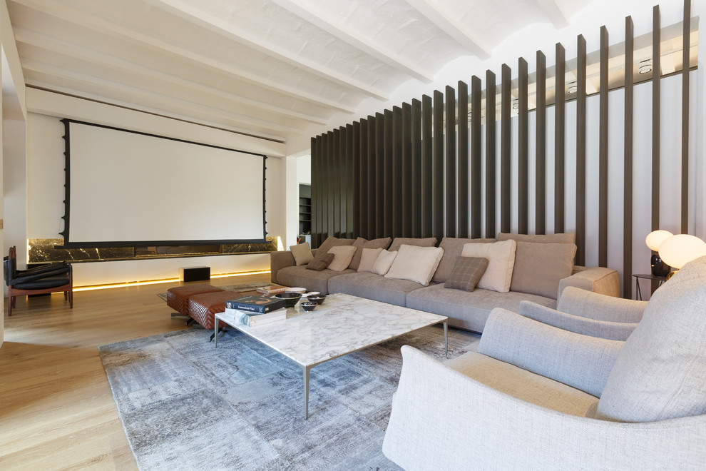 Idée de décoration pour une très grande salle de cinéma urbaine ouverte avec un mur blanc, un sol en bois brun et un écran de projection.