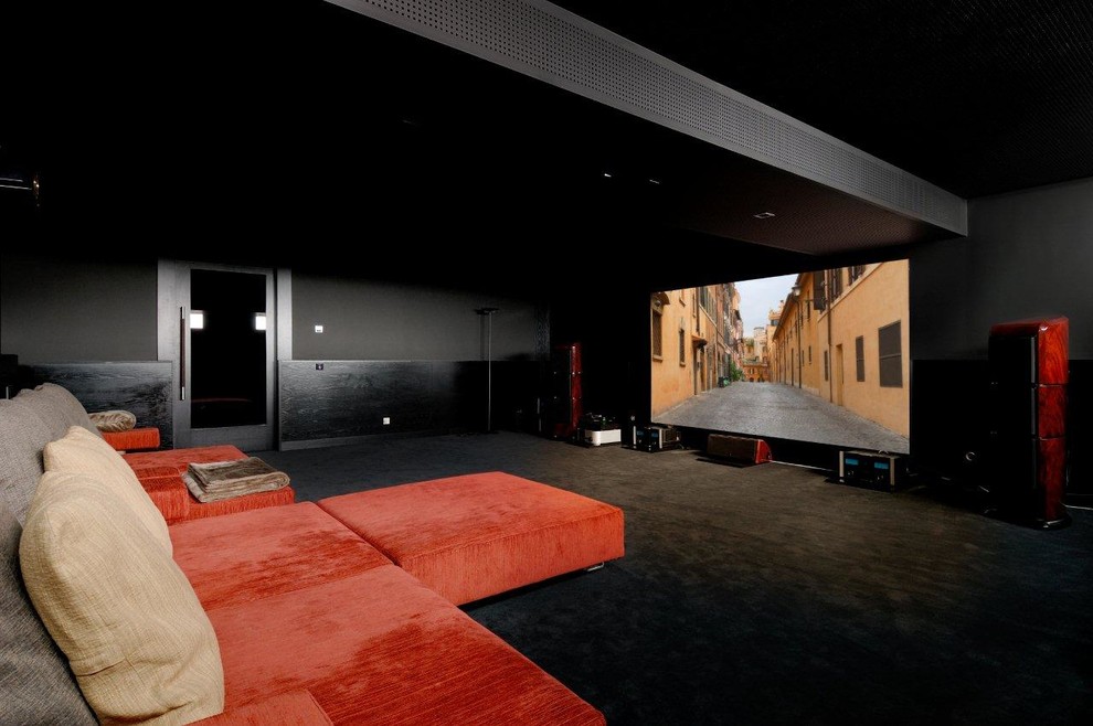 This is an example of a large contemporary enclosed home cinema in Madrid with black walls, carpet and a projector screen.