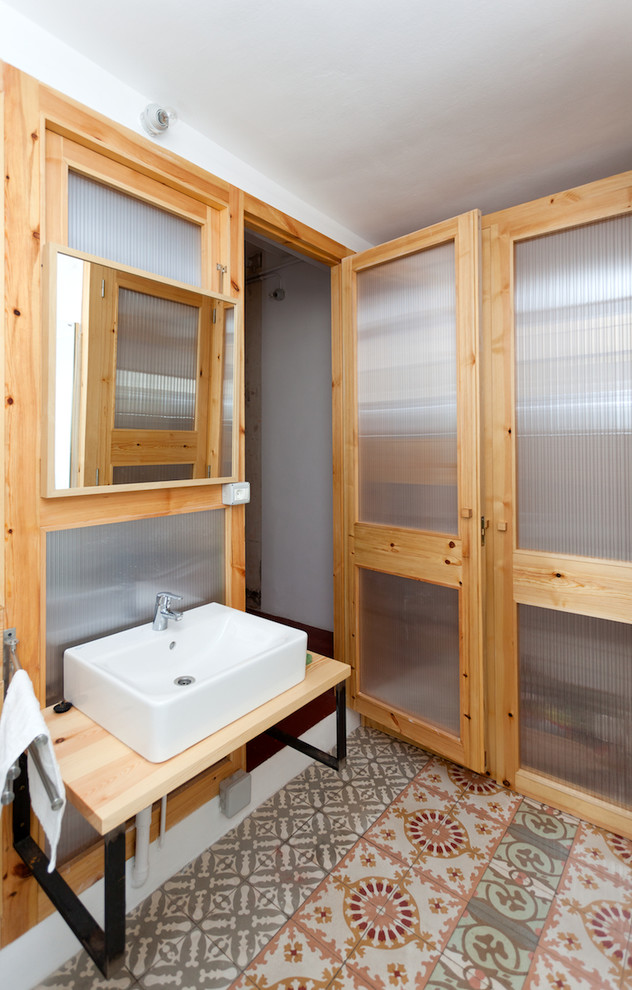Mittelgroße Industrial Gästetoilette mit Waschtisch aus Holz, farbigen Fliesen, Aufsatzwaschbecken, Keramikboden und beiger Waschtischplatte in Barcelona
