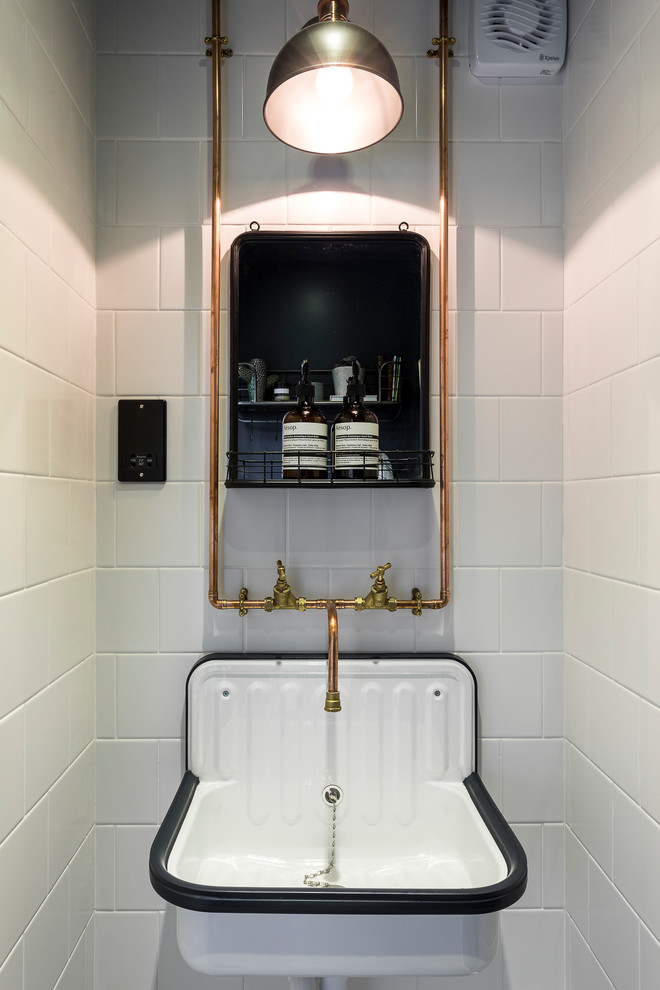 Exempel på ett litet nordiskt toalett, med vit kakel, vita väggar och ett väggmonterat handfat