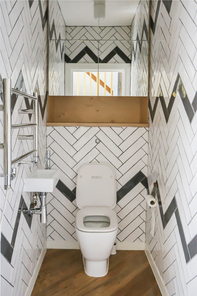 Moderne Gästetoilette mit offenen Schränken, hellbraunen Holzschränken, Toilette mit Aufsatzspülkasten, bunten Wänden, Wandwaschbecken, braunem Holzboden und braunem Boden in London