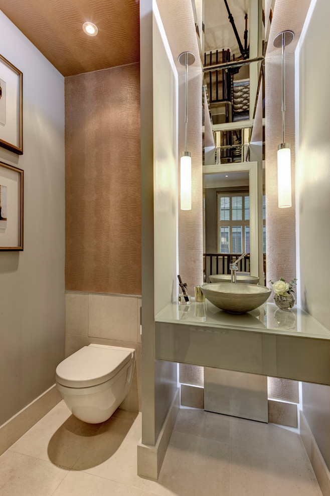 Réalisation d'un grand WC suspendu minimaliste avec un carrelage beige, un mur beige, une vasque et un plan de toilette en verre.