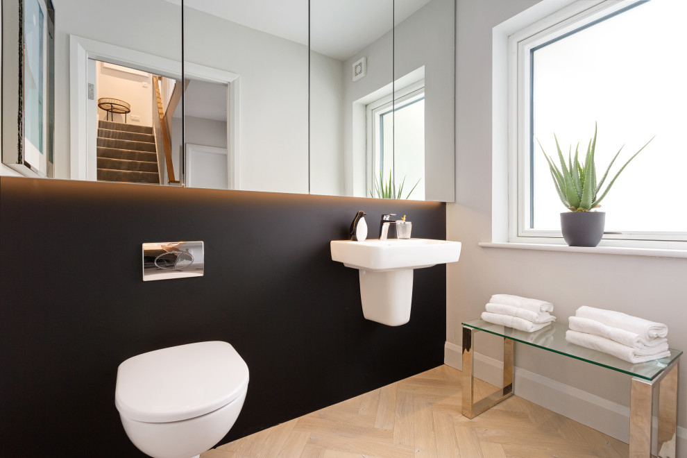 Mittelgroße Moderne Gästetoilette mit Wandtoilette, schwarzer Wandfarbe, Wandwaschbecken und beigem Boden in Dublin