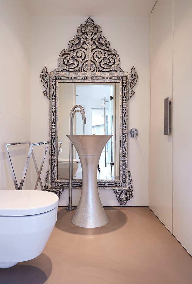 ロンドンにある中くらいな地中海スタイルのおしゃれなトイレ・洗面所 (フラットパネル扉のキャビネット、白いキャビネット、壁掛け式トイレ、白い壁、オレンジの床) の写真