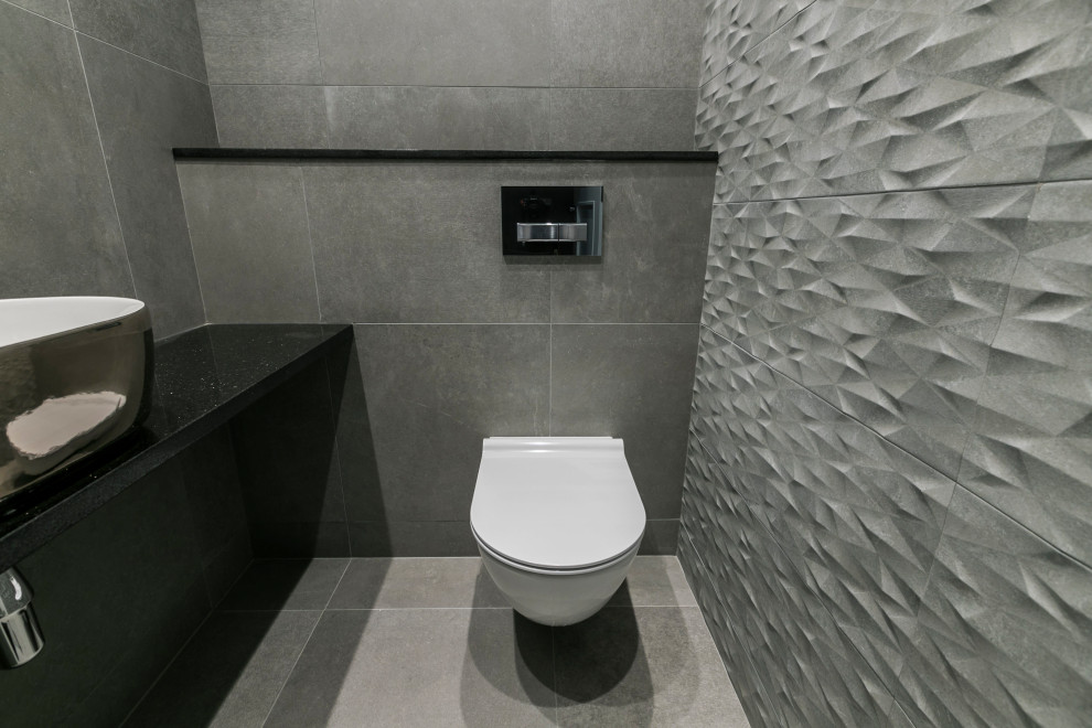 Idées déco pour un petit WC suspendu moderne avec un carrelage gris, des carreaux de porcelaine, un mur gris, un sol en carrelage de porcelaine, un lavabo intégré, un plan de toilette en quartz, un sol gris, un plan de toilette noir, meuble-lavabo suspendu et un plafond décaissé.