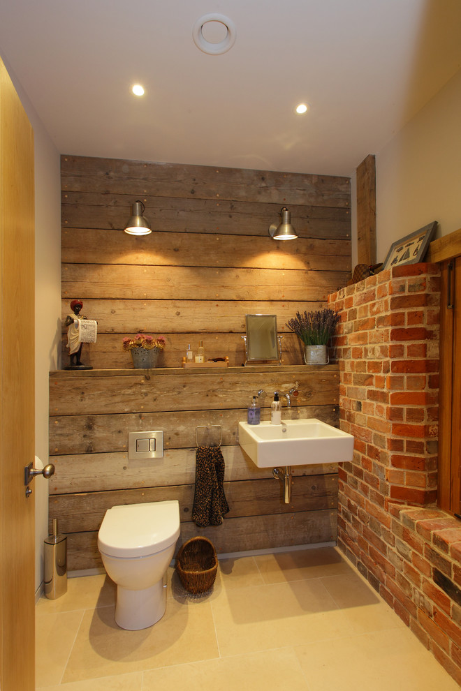 Foto på ett mellanstort rustikt toalett, med ett väggmonterat handfat och en toalettstol med hel cisternkåpa