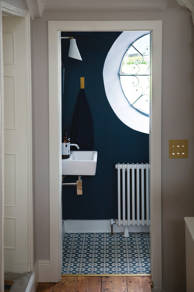 ダブリンにあるトラディショナルスタイルのおしゃれなトイレ・洗面所 (マルチカラーのタイル、青い壁、壁付け型シンク、セラミックタイルの床) の写真